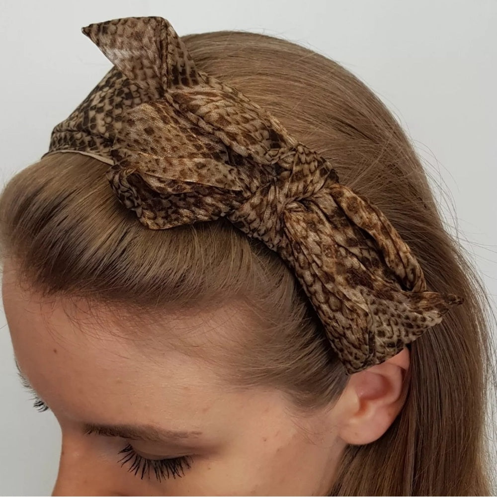 Nuevo accesorio para el cabello de mujer de Claire: diadema de plástico con estampado de serpiente y lazo