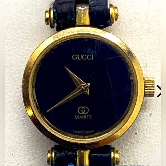 复古 Gucci 金色黑色调手表，搭配皮革表带。